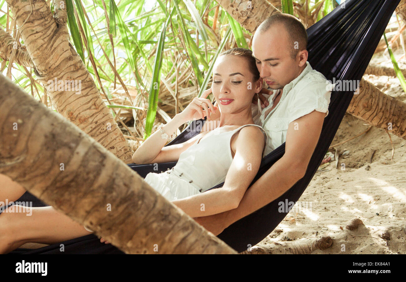 Junge schöne liegen in der Hängematte zu zweit und genießen einander Stockfoto