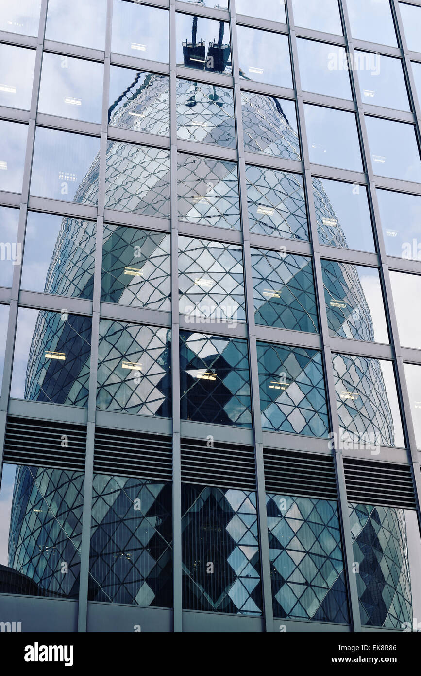 Gherkin Gebäudes spiegelt sich in das Glas von einem angrenzenden Bürogebäude, 30 St Mary Axe, London, UK. Stockfoto