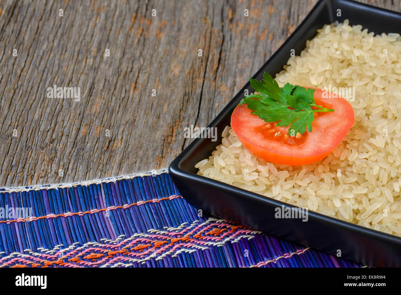 Platte mit ungekochtem Reis und Tomaten Scheibe Stockfoto