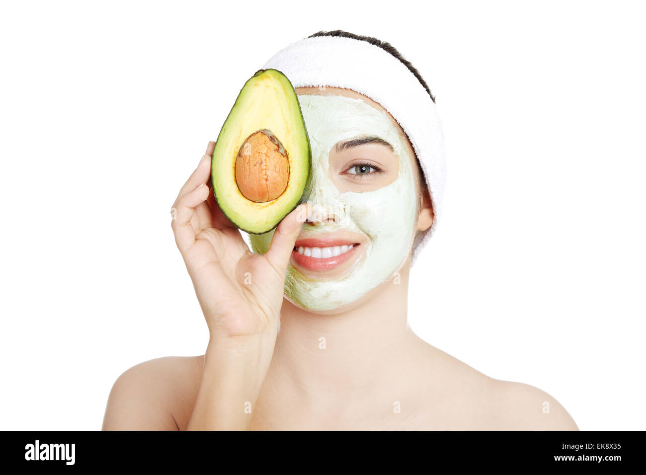Junge Frau mit einem Lächeln halten mit avocado Stockfoto
