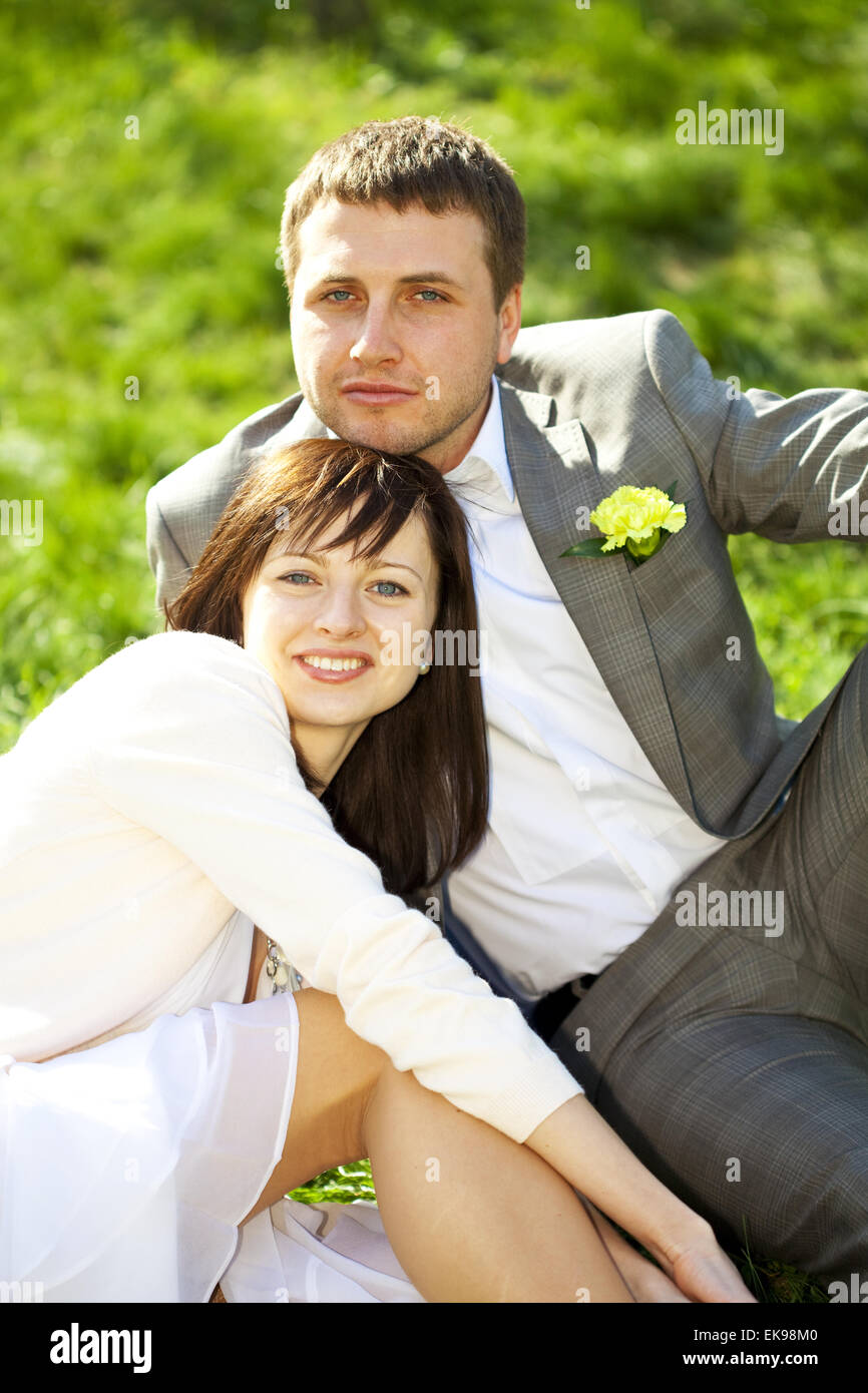 Gerade in einem blühenden Garten sitzen auf dem Rasen geheiratet Stockfoto