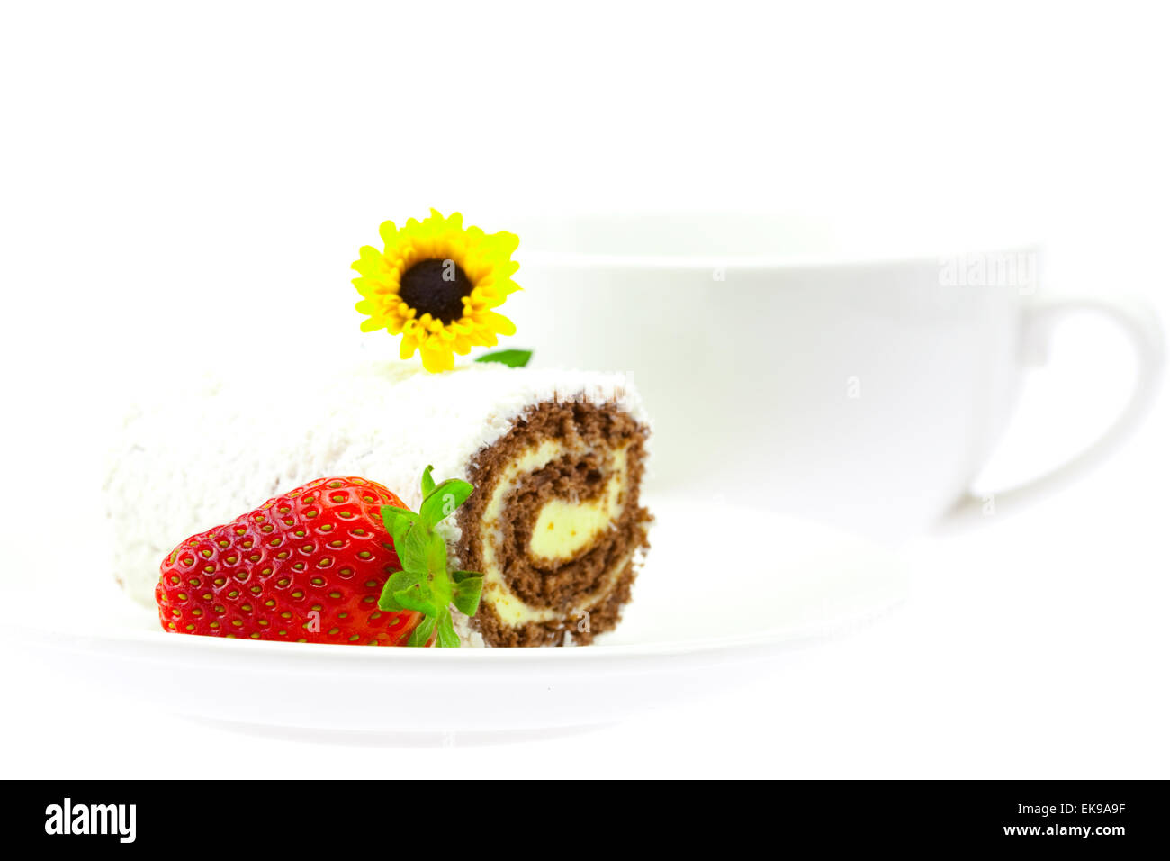 Rollen Sie süße liegen auf der Untertasse Tasse Blumen und Erdbeeren isola Stockfoto