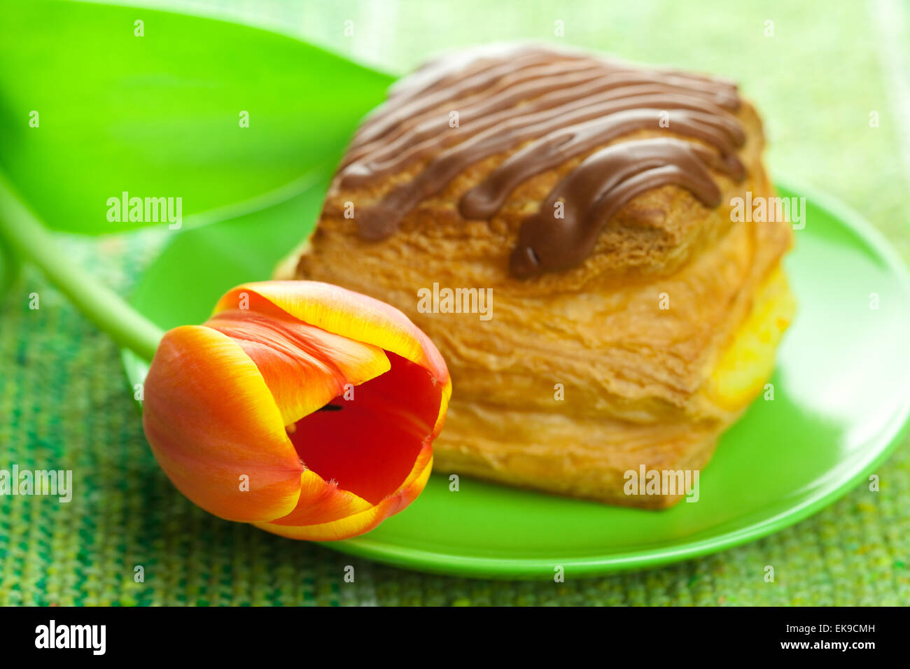 Kuchen mit Schokolade und Tulpen auf einem Teller auf den Stoff Stockfoto