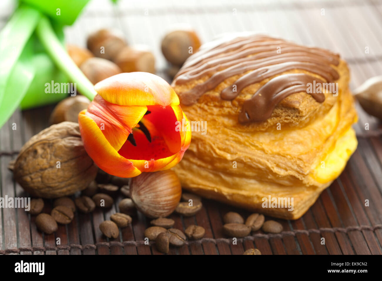 Kuchen mit Schokolade, Kaffeebohne, Tulpe und Nüssen auf ein Bamb liegend Stockfoto