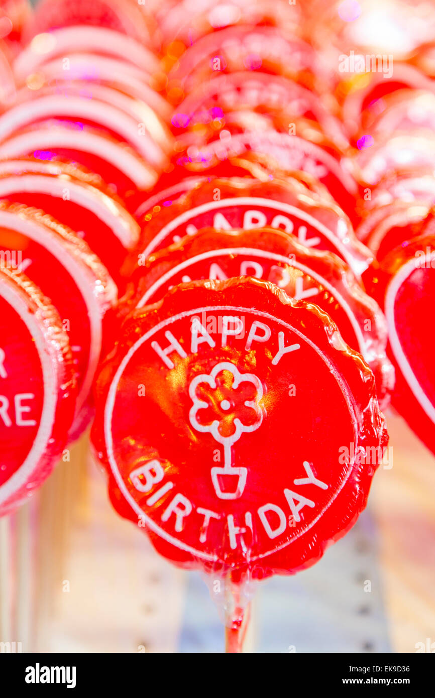 Ein Bild aus einer Reihe von Happy Birthday Lutscher auf Stöcken in leuchtendem Rot Stockfoto