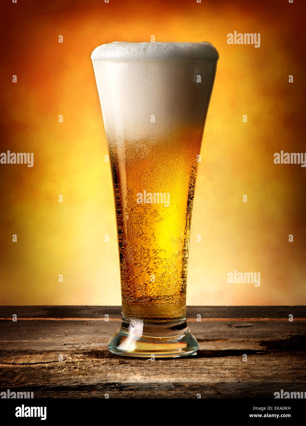 Glas Bier mit Luftblasen auf einem Holztisch Stockfoto