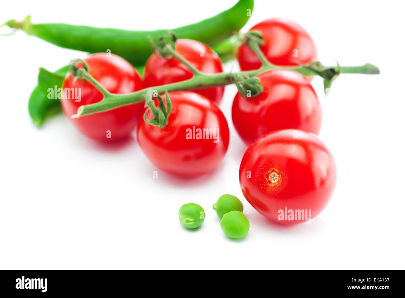 jede Menge Tomaten und Erbsen isoliert auf weiss Stockfoto