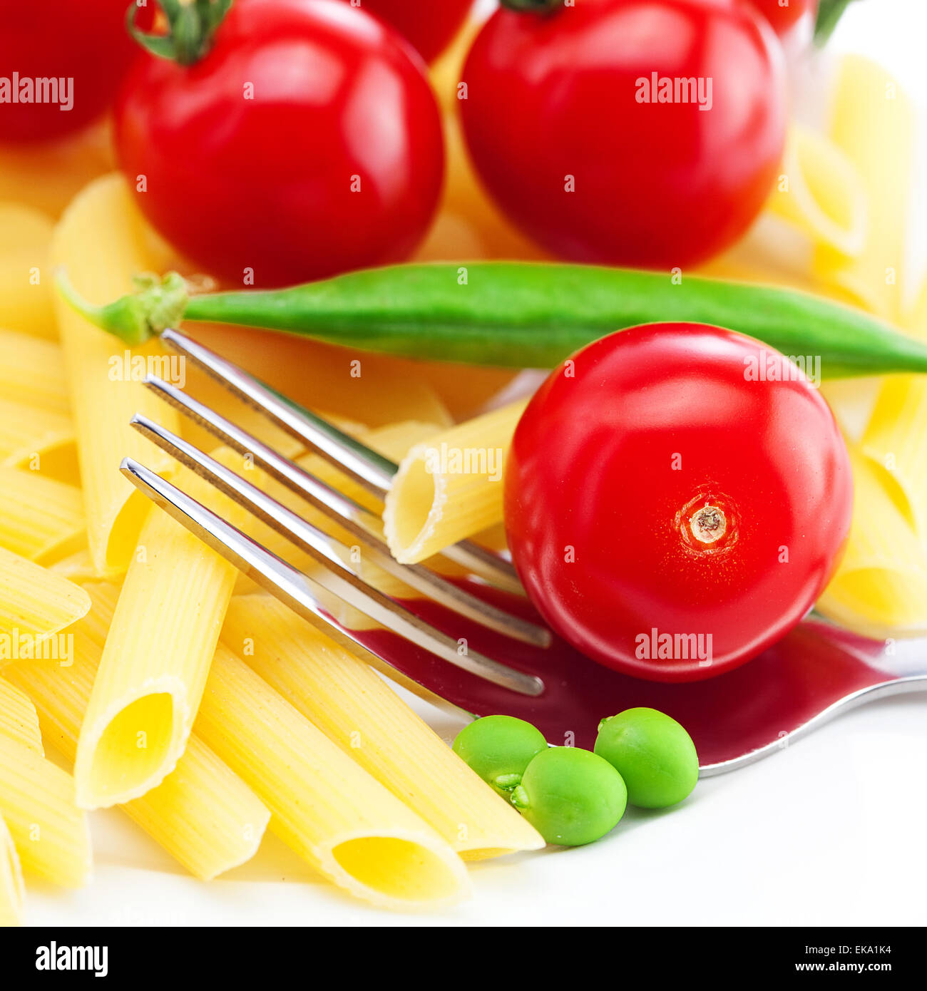 Tomaten, Erbsen, Nudeln und Gabel auf einem Teller isoliert auf weiss Stockfoto