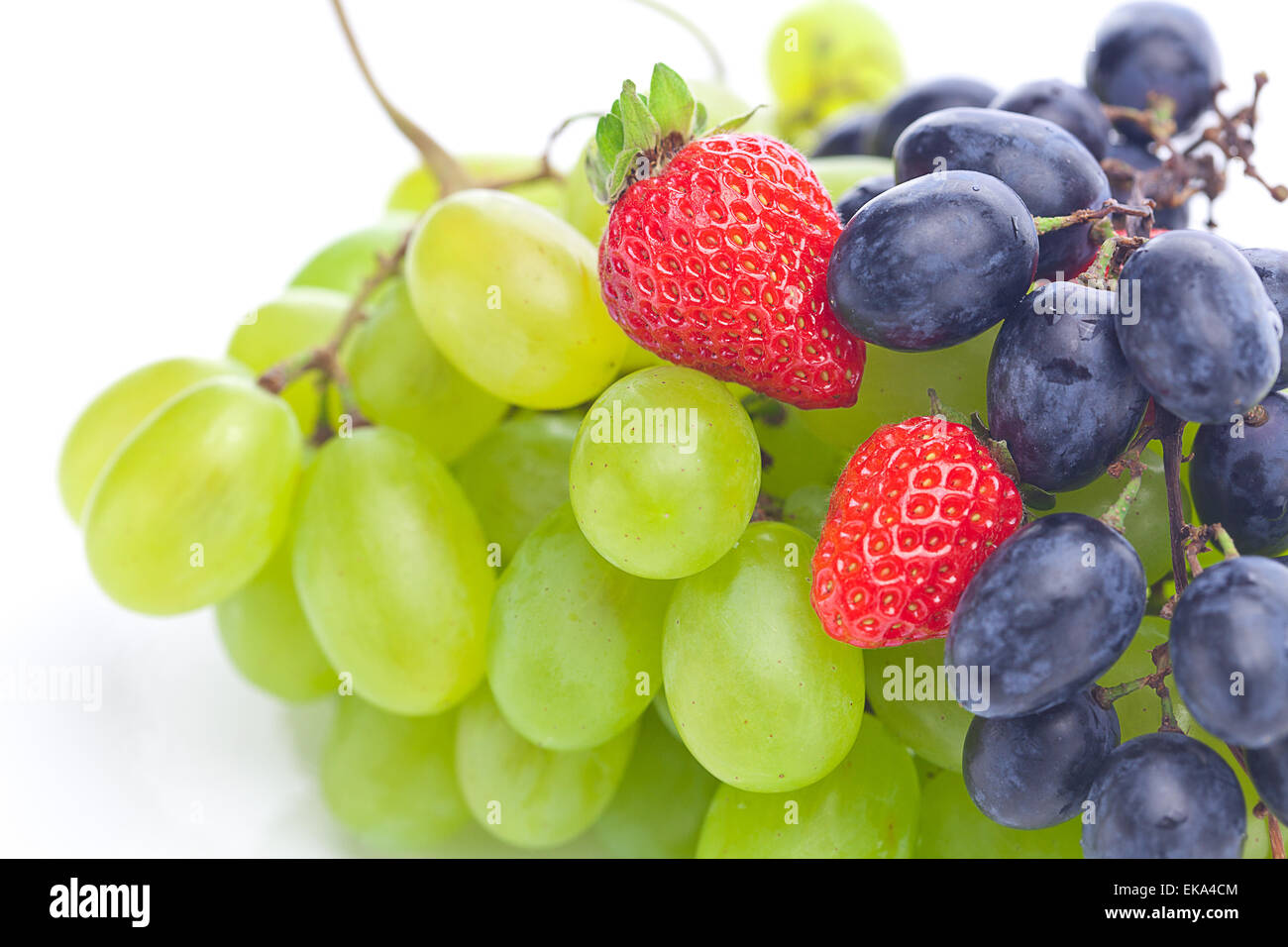 jede Menge weiße und schwarze Trauben und Erdbeeren isoliert auf whi Stockfoto