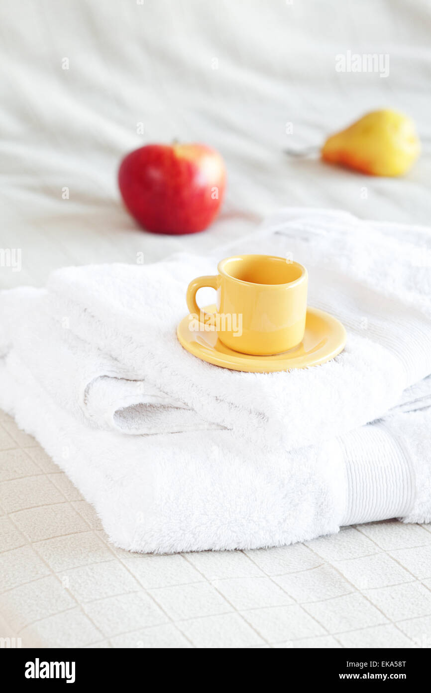 Tasse Tee, Apfel und Birne auf dem Bett Stockfoto