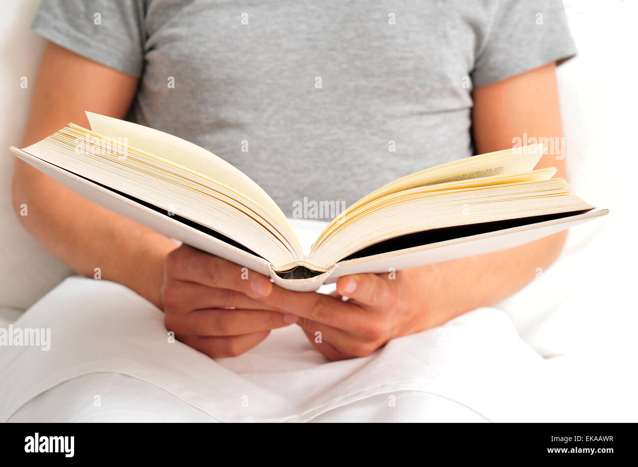 Closeup von einem kaukasischen Jüngling ein Buch im Bett lesen Stockfoto