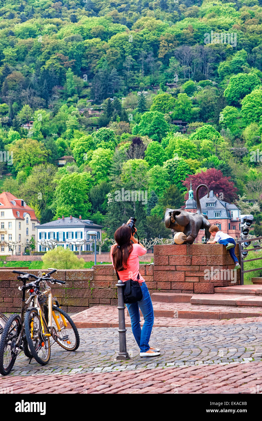 Jungen spielen in der Nähe von Bronze Affenstatue auf der Brücke im Sommer Heidelberg und Frauen mit Kamera Stockfoto