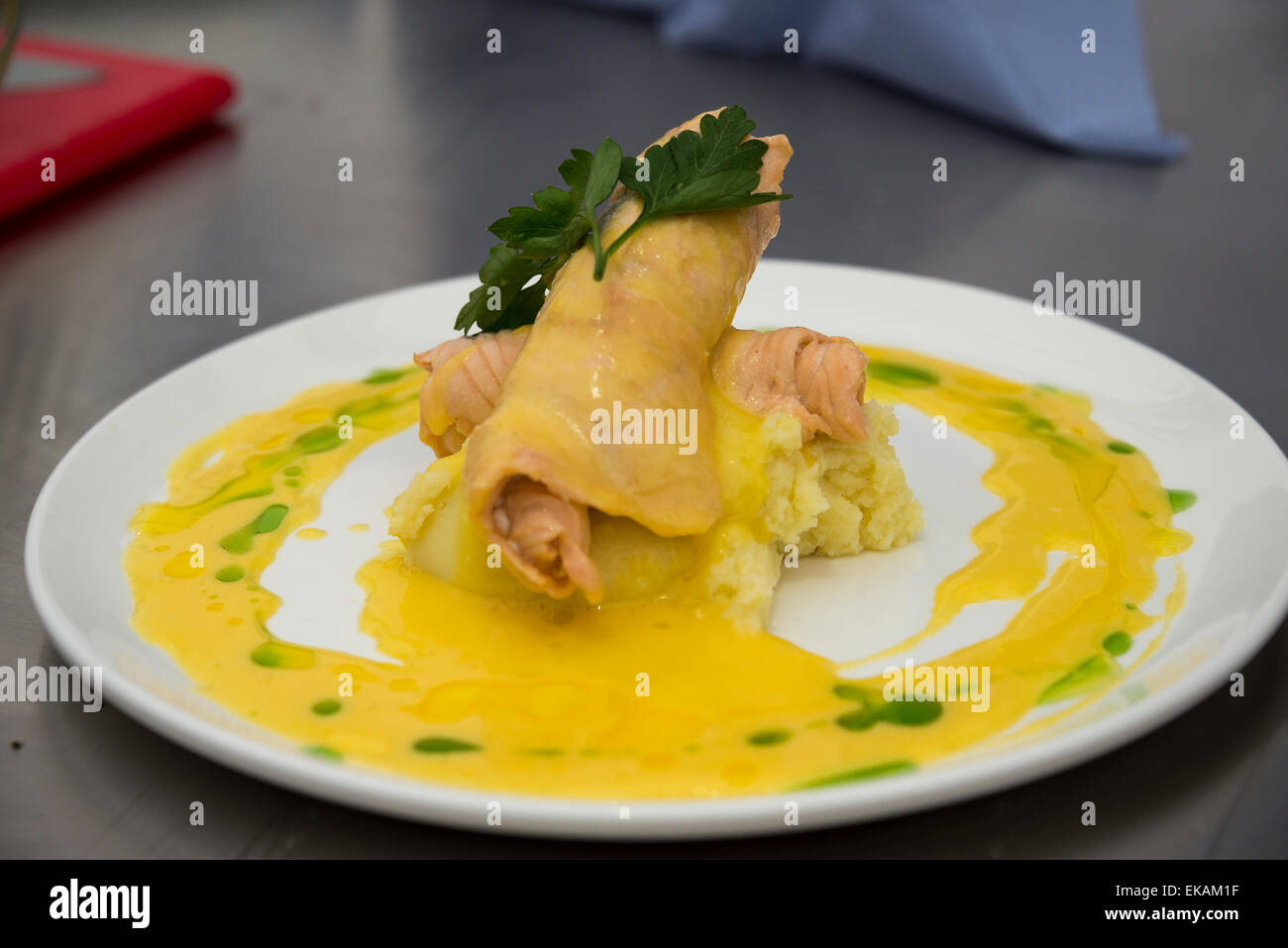 Essen auf dem Teller - Fischgericht serviert auf einem Bett aus Kartoffelpüree mit Bearnaise Sauce. Stockfoto