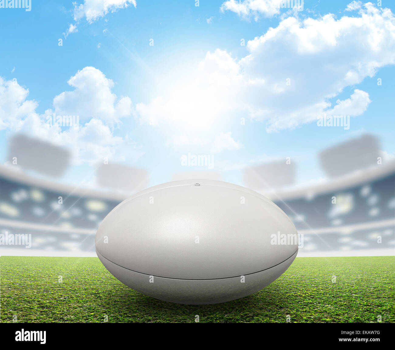 Ein Rugby-Stadion mit einem generischen weißen Rugby-Ball auf einem markierten grünen Rasenplatz tagsüber unter blauem Himmel Stockfoto