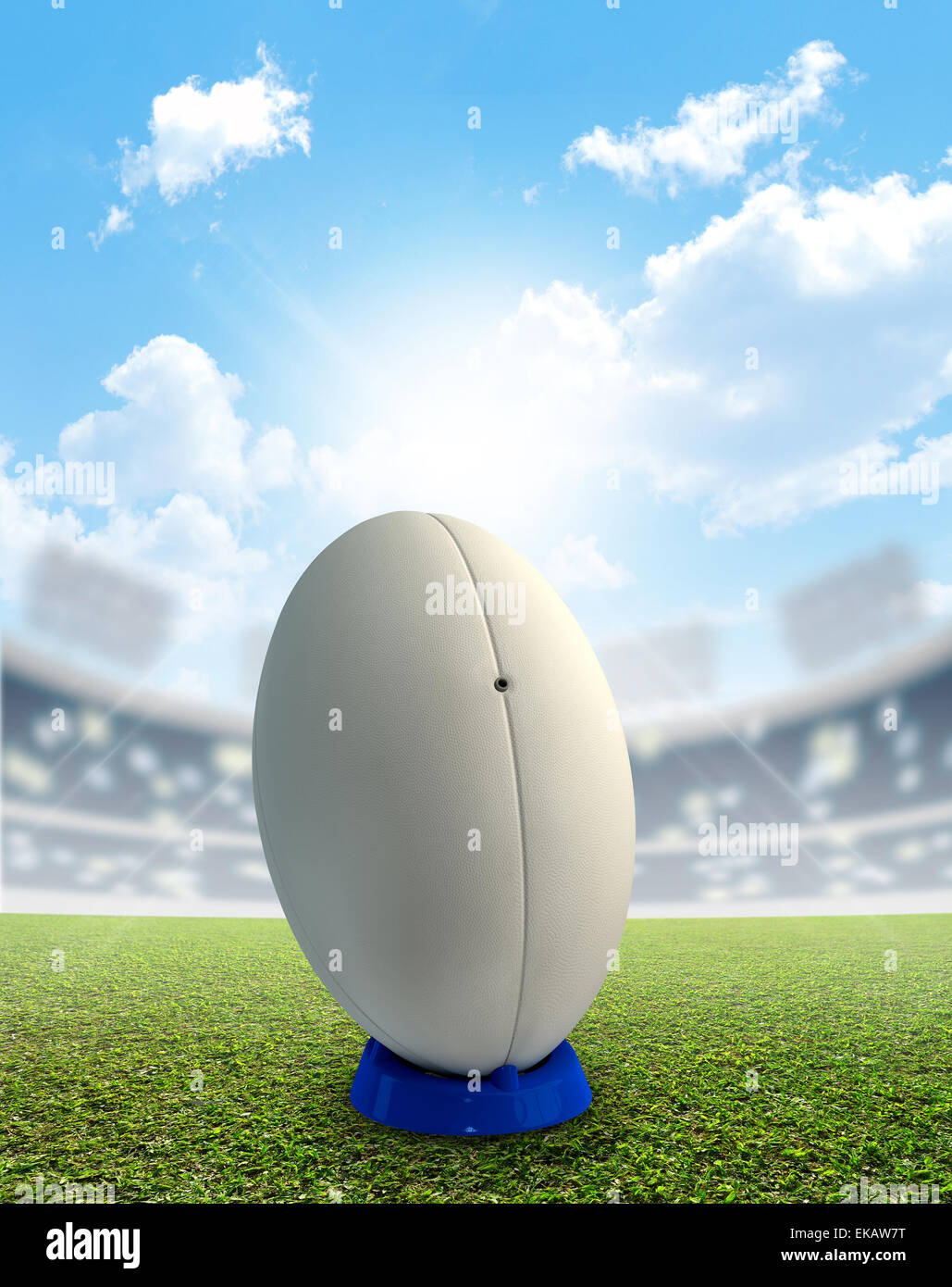 Ein Rugby-Stadion mit einem generischen weißen Rugby-Ball auf einem blau treten Abschlag auf einem markierten grünen Rasenplatz tagsüber unter einem blauen Stockfoto