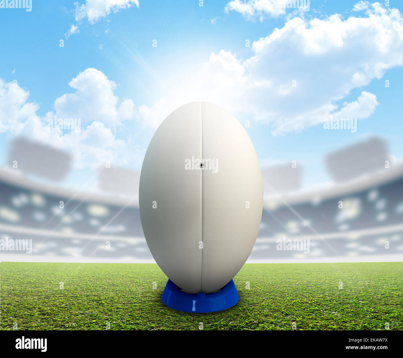 Ein Rugby-Stadion mit einem generischen weißen Rugby-Ball auf einem blau treten Abschlag auf einem markierten grünen Rasenplatz tagsüber unter einem blauen Stockfoto