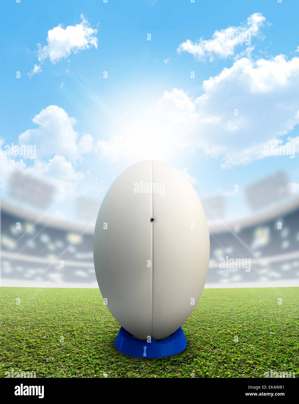 Ein Rugby-Stadion mit einem generischen weißen Rugby-Ball auf einem blau treten Abschlag auf einem markierten grünen Rasenplatz tagsüber unter einem blauen Stockfoto