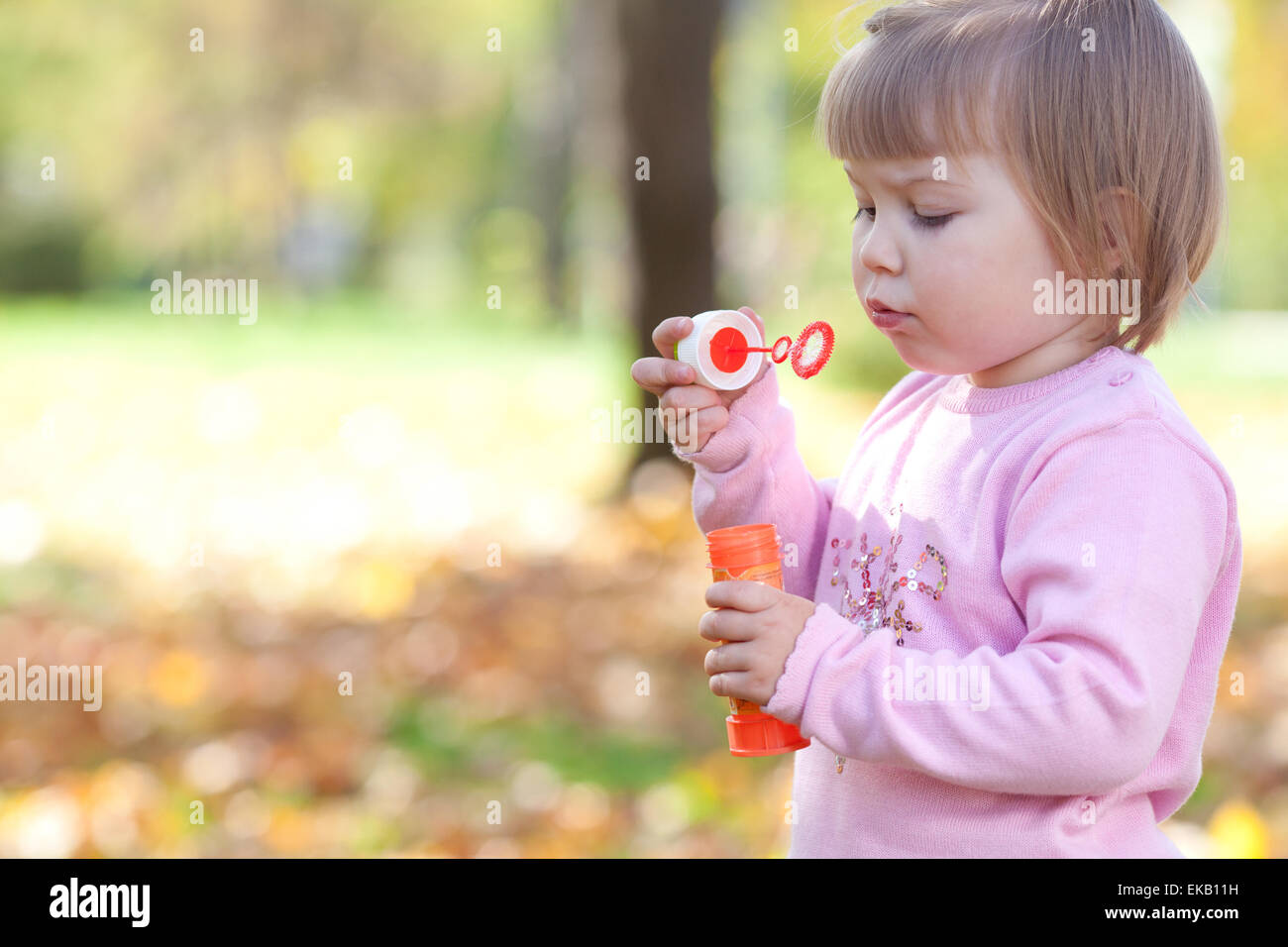 wunderschönes kleines Mädchen machen Blase Gebläse auf den herbstlichen Wald Stockfoto