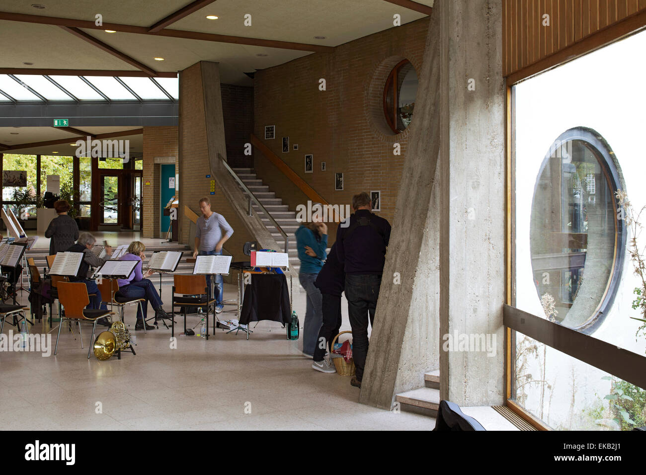 Haupteingangshalle mit Musikern geprobt. Scharouns Marl-Schule, Marl, Deutschland. Architekt: Hans Scharoun, 1975. Stockfoto