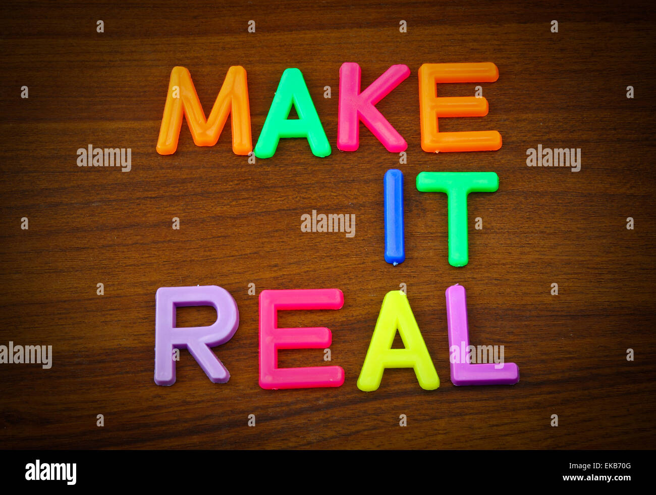 Mach es in bunten Spielzeug-Briefen auf Holz Hintergrund Stockfoto