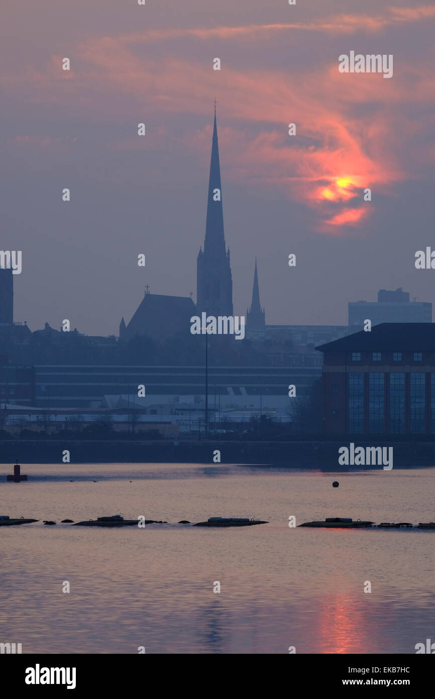 Preston, Lancashire: Die Sonne geht über Preston Docks mit St. Walburge Kirchturm in der Ferne Stockfoto