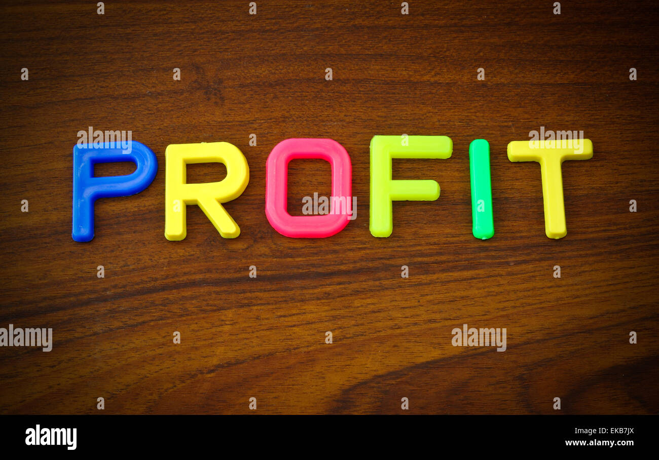 profitieren Sie in bunten Spielzeug-Buchstaben auf Holz Hintergrund Stockfoto