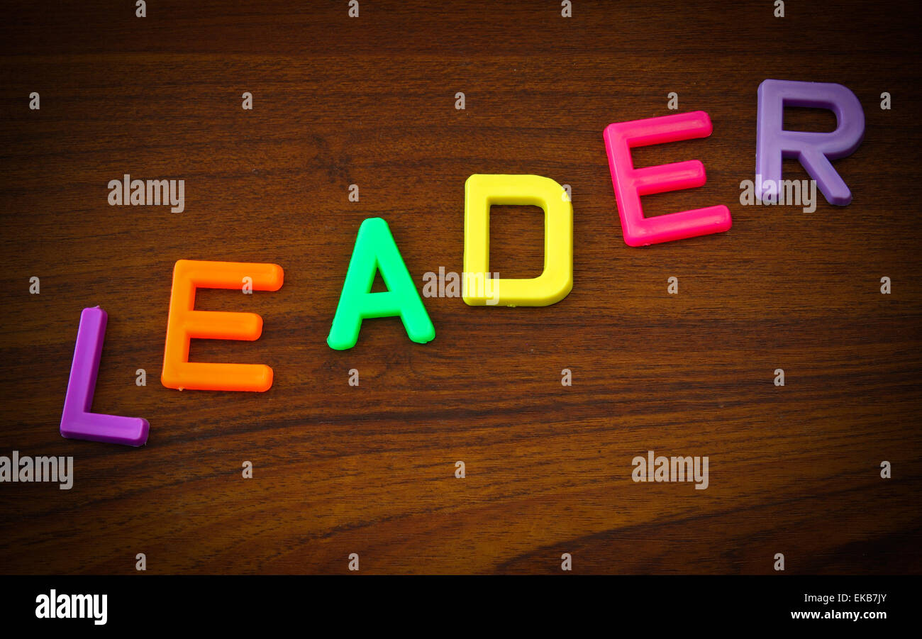 Führend in der bunten Spielzeug-Buchstaben auf Holz Hintergrund Stockfoto