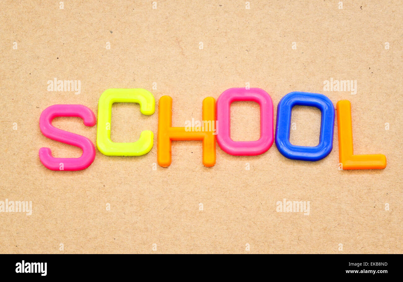 Schule in bunten Spielzeug-Buchstaben auf Papierhintergrund Stockfoto