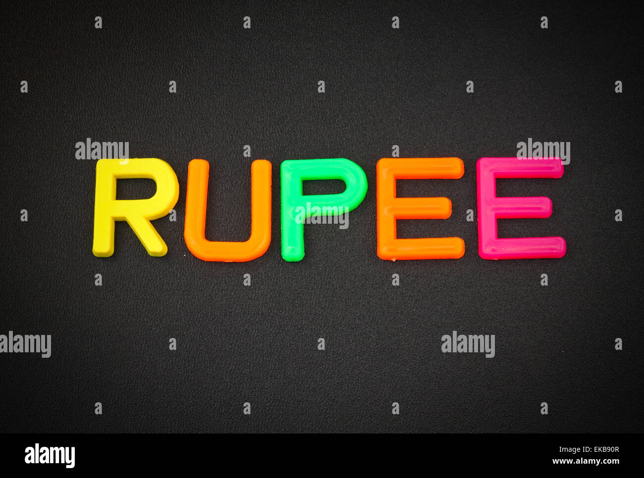 Rupie in bunten Spielzeug Buchstaben auf schwarzem Hintergrund Stockfoto