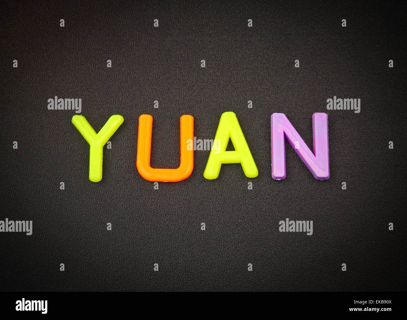 Yuan in bunten Spielzeug Buchstaben auf schwarzem Hintergrund Stockfoto