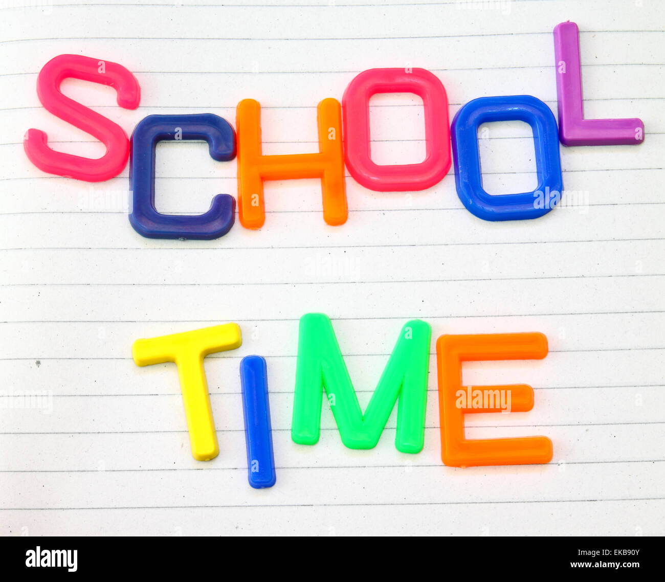 Schulzeit in bunten Spielzeug-Buchstaben auf Liniertes Papierhintergrund Stockfoto
