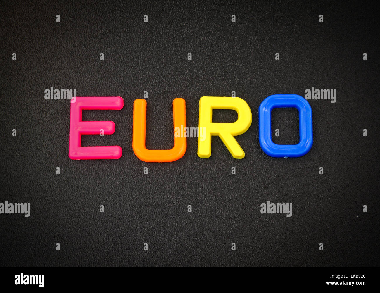 Euro in bunten Spielzeug Buchstaben auf schwarzem Hintergrund Stockfoto