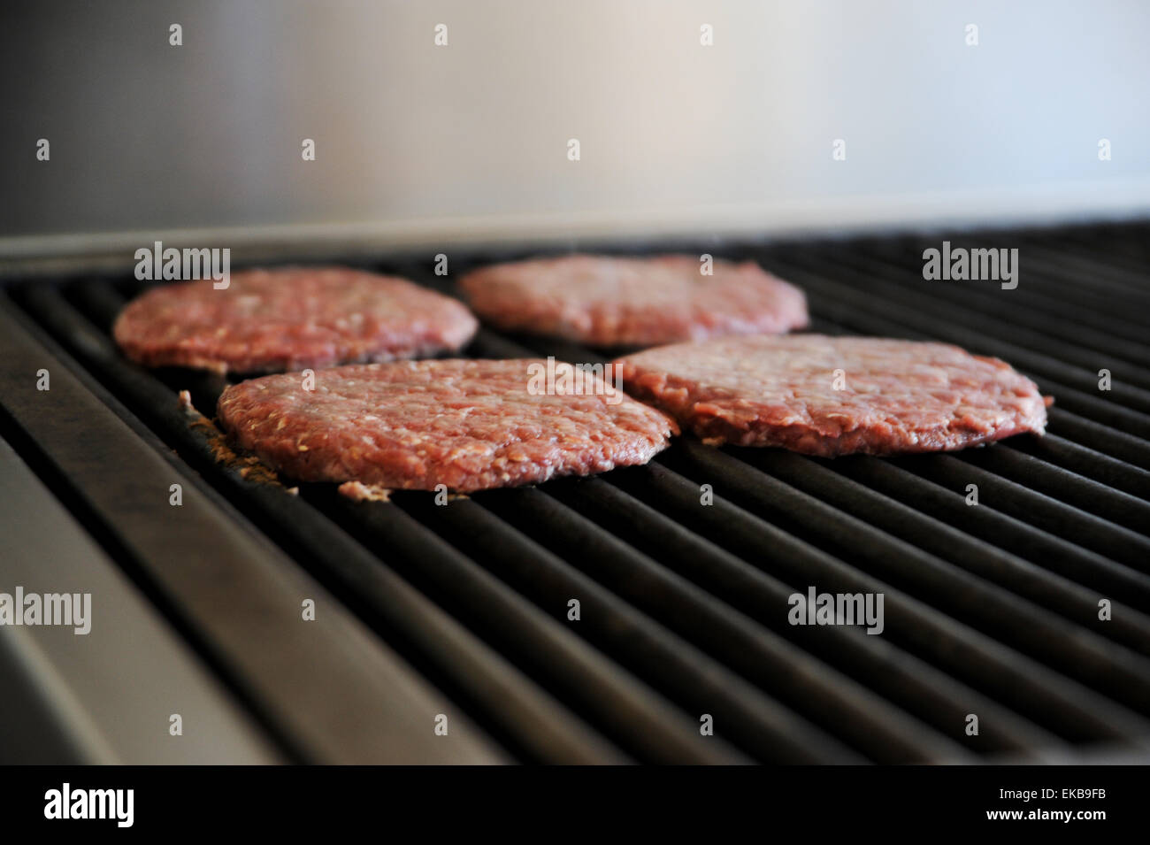 Frisch zubereitete Burger mit Rindfleisch Kochen auf einer heißen Bratpfanne an ein Fast-Food Take away shop Stockfoto