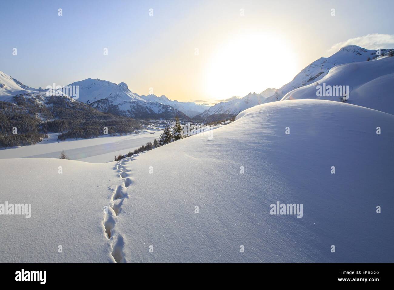 Fußabdrücke marschieren in Richtung Maloja-Pass unter der Sonne durch den Nebel verhüllt, an einem kalten Wintertag, Maloja, Graubünden, Schweiz Stockfoto