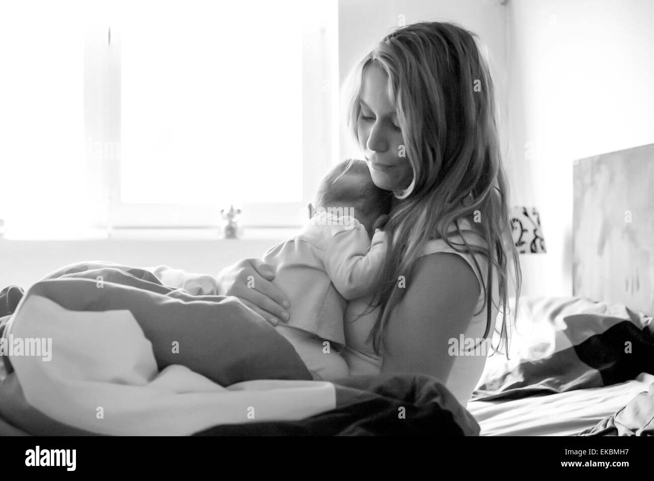 Baby schläft Om Mütter Arme in schwarz / weiß Stockfoto