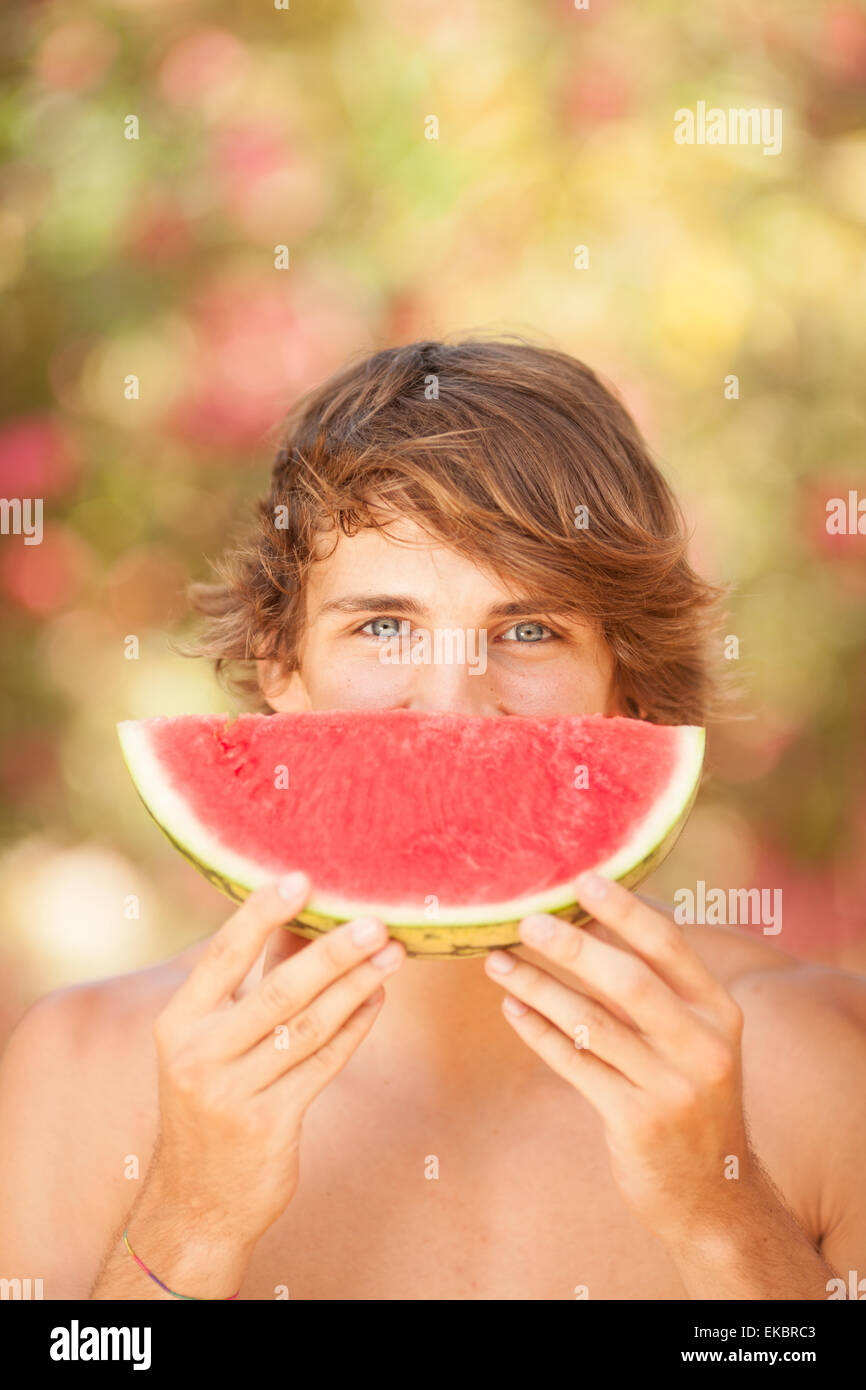Porträt einer schönen jungen Mann Essen Wassermelone Stockfoto