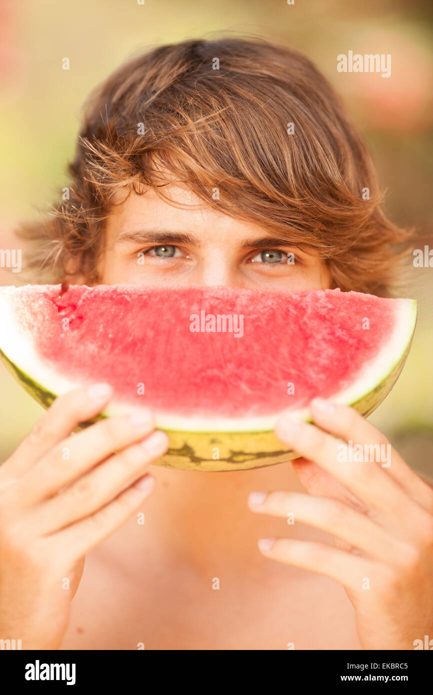 Porträt einer schönen jungen Mann Essen Wassermelone Stockfoto