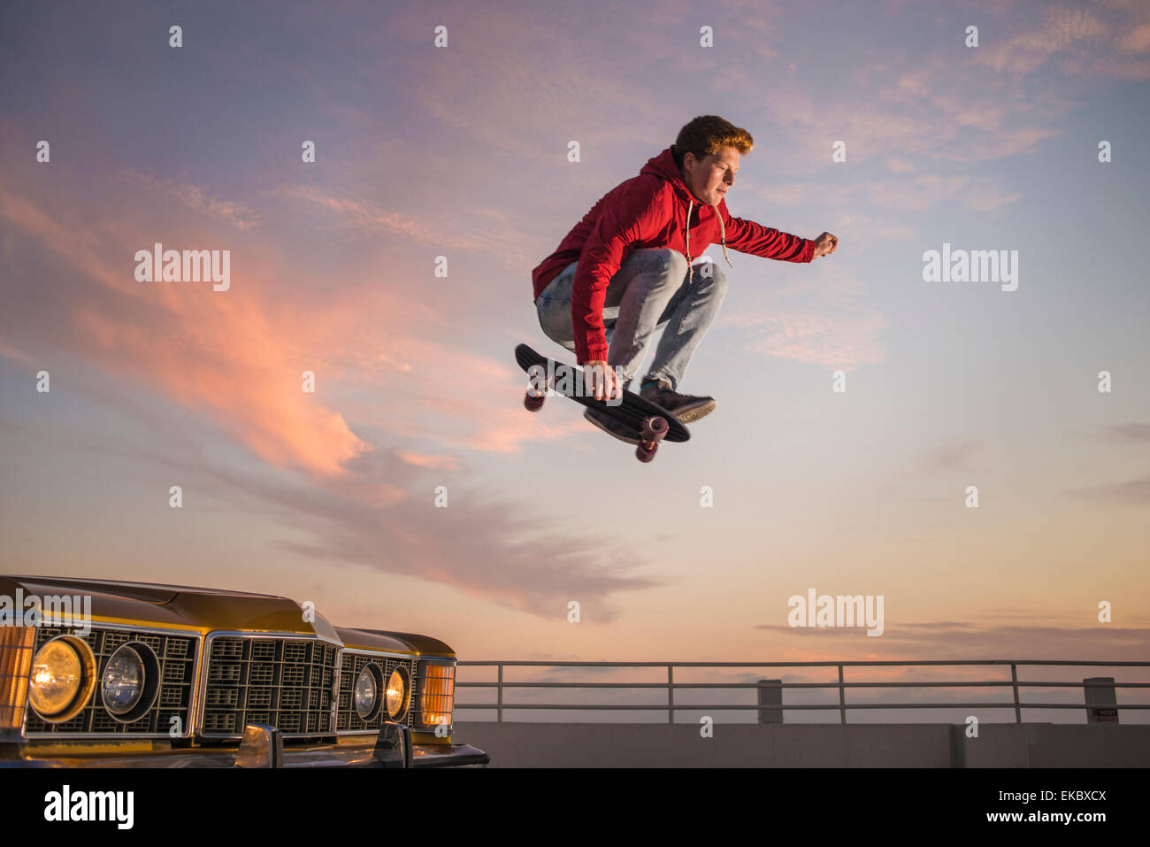 Porträt des jungen Mannes auf Skateboard in der Luft Stockfoto