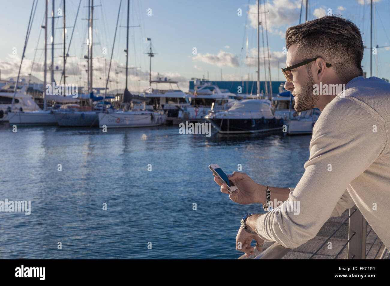 Junger Mann mit Smartphone von Hafen, Cagliari, Sardinien, Italien Stockfoto