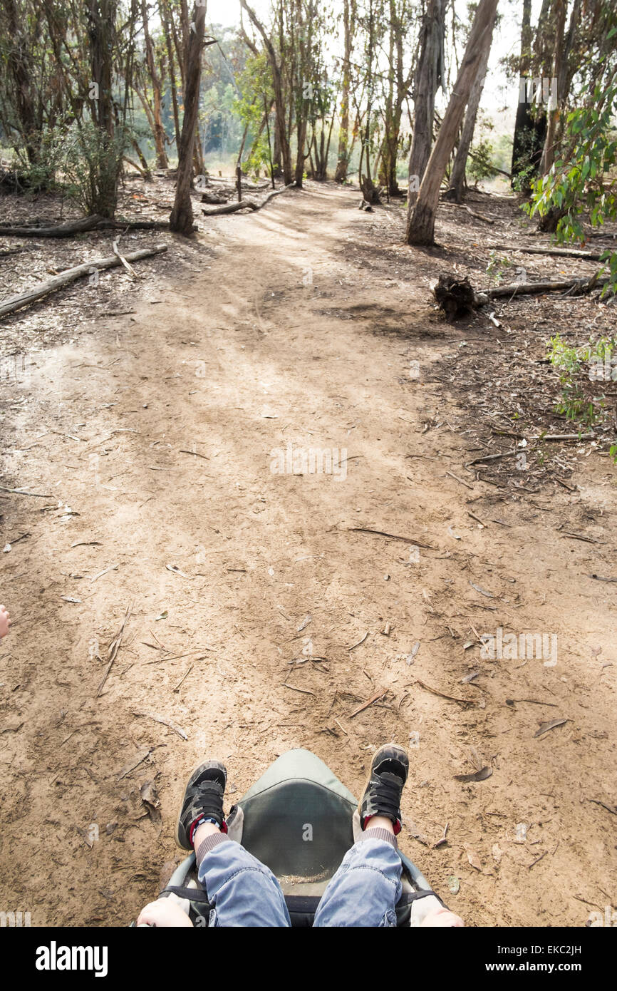 Des jungen Beine ragen Buggy in Wäldern, obenliegende Ansicht Stockfoto