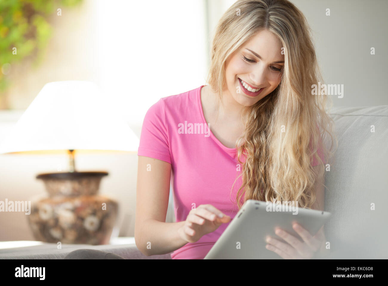 junge schöne Frau mit Tablet zu Hause Stockfoto