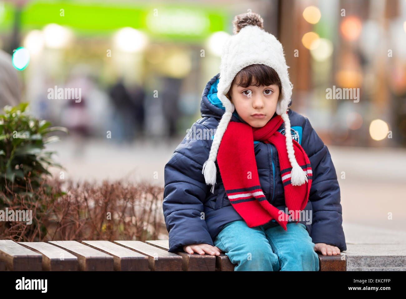 Traurige Junge sitzt auf einer Bank Stockfoto