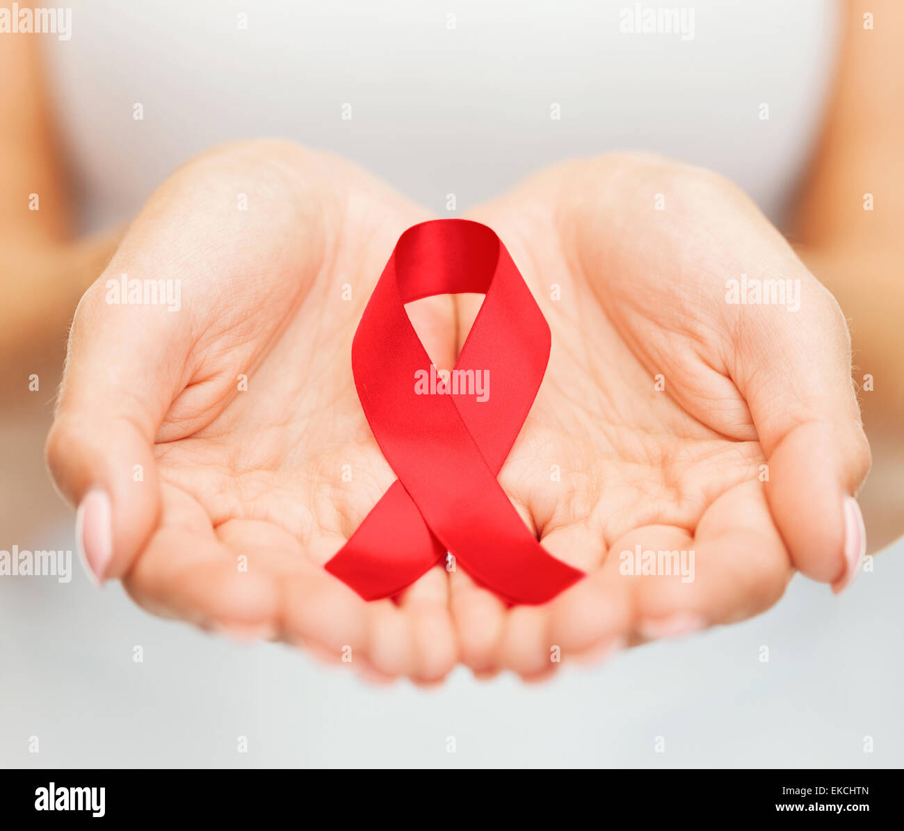 Hände halten rote AIDS-Schleife Stockfoto