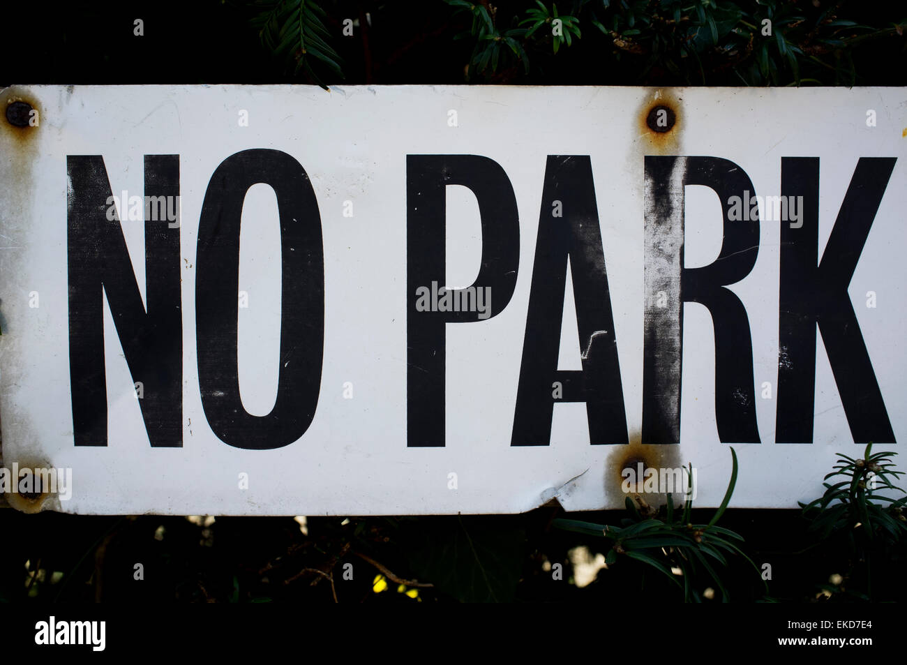 Kein Parkschild, schwarzen Buchstaben auf weißem Hintergrund. Alte/Vintage Schild mit rostigen Nieten gehalten. Stockfoto