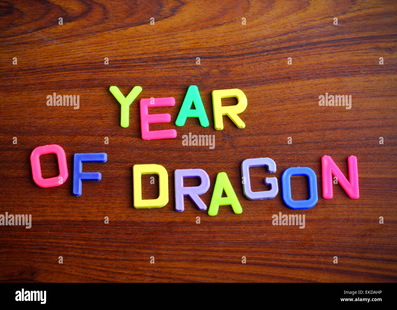 Jahr des Drachen in bunten Spielzeug-Buchstaben auf Holz Hintergrund Stockfoto