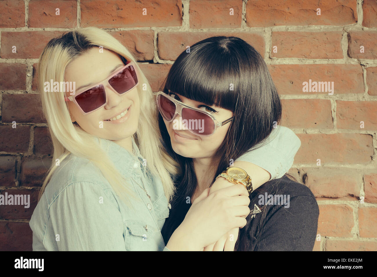 Hautnah Fashion Portrait von zwei Mädchen Umarmungen und gemeinsam Spaß haben, stilvolle Sonnenbrille best Fiend tolle Zeit gemeinsam genießen. Stockfoto