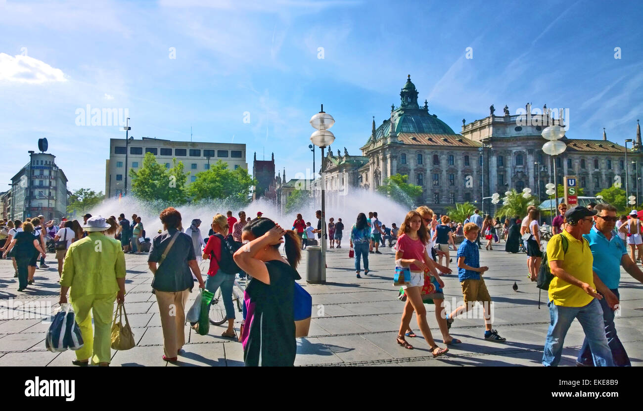 München, Deutschland - warmer Sommertag, Leute zu Fuß und Spaziergang rund um den Brunnen am Halbrundbogen-Stachus Stockfoto