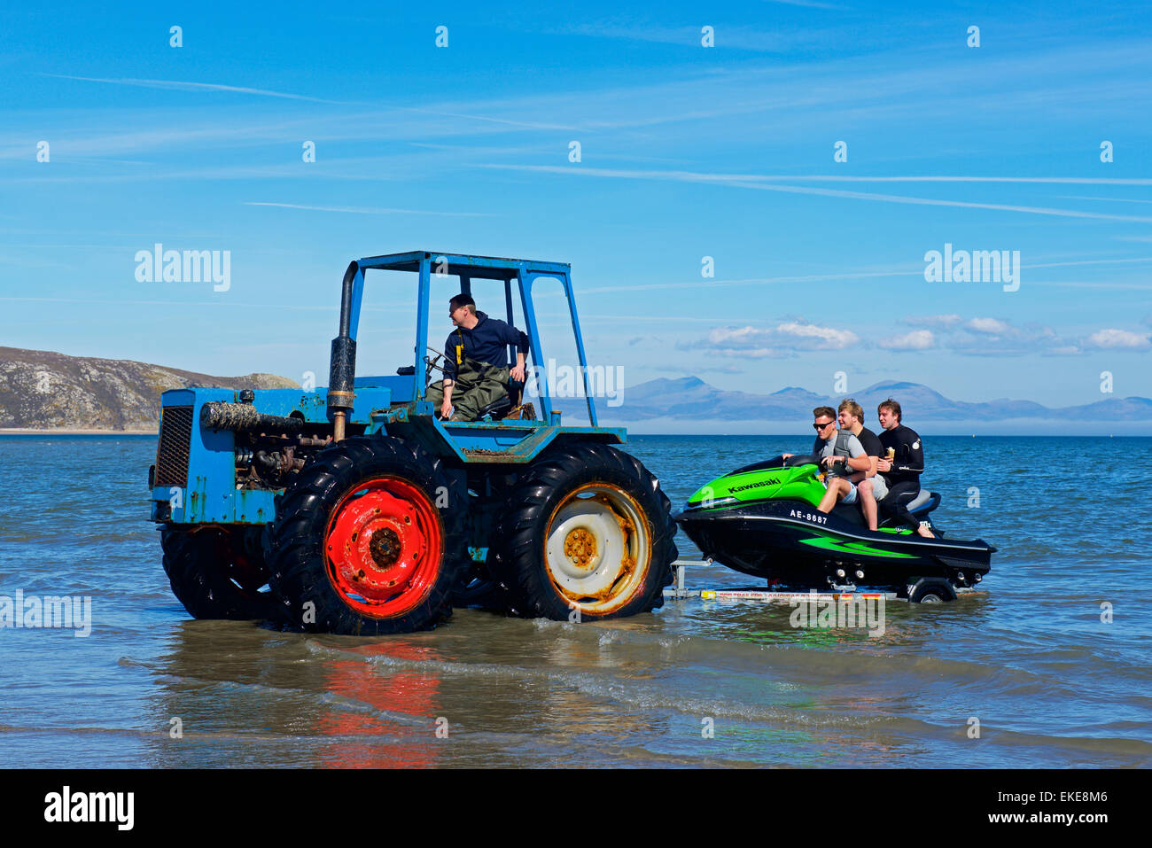 Drei Jungs auf Jetski abgeschleppt aus dem Meer mit einem Traktor, Abersoch, Gwynedd, North Wales UK Stockfoto