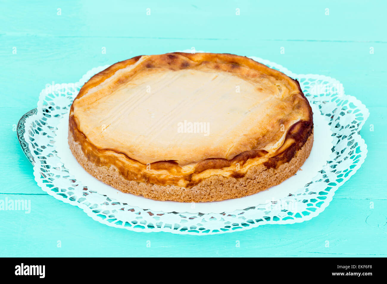 Käsekuchen auf einem Türkis Holz mit Kuchen-Spitze. Stockfoto