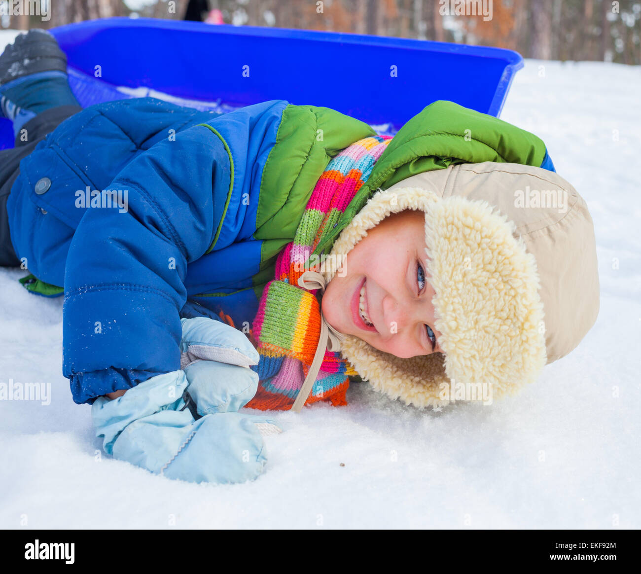 Junge auf Schlitten im Schnee Stockfoto